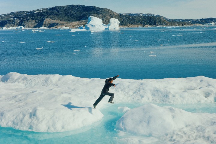 Junge springt in Kullorsuaq, Grönland über Eisfeld.